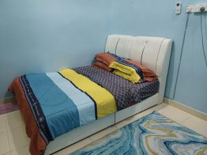 a bed with a white frame in a room at Homestay Dalia, Beseri, Perlis in Kangar