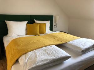 ein großes Bett mit gelber Decke drauf in der Unterkunft Villa zur Schmied'n in Ehrenhausen