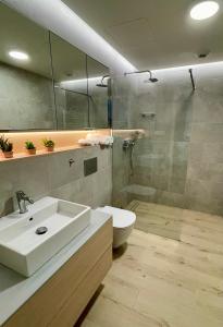 un bagno con lavandino, WC e doccia di Apartament Pinea 410 Pobierowo przy plaży bezpłatny dostęp do basenu i saun 100m od głównej promenady, bezpłatny strzeżony parking! a Pobierowo