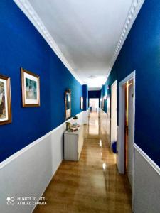a hallway with blue walls and wood floors and a hallway with a hallway at PICCOLO HOTEL Con Access ZTL !!! Ɲel Ƈentro Storico di Ƒirenze !!! in Florence