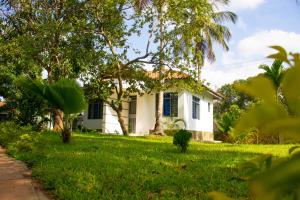 ein weißes Haus mit einer Palme im Hof in der Unterkunft Cycad Palm Diani in Diani Beach