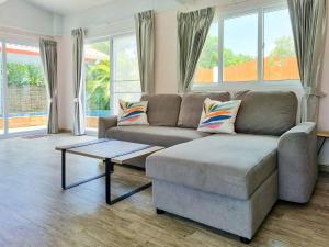 sala de estar con sofá y mesa de centro en Tina's Living Paradise II - Guesthouses with private pool, 5 min to beach en Rayong