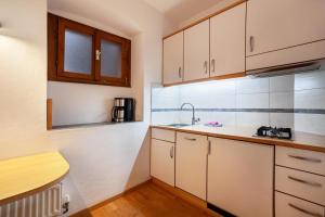 a kitchen with white cabinets and a sink at Camping Passeier Alpenrose in Saltusio