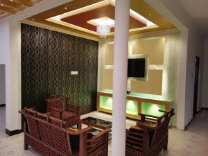 a lobby with chairs and a tv in a room at Nallur Holidays Inn in Jaffna