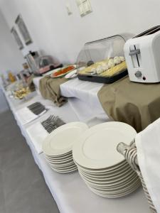 einem Tisch mit weißen Platten auf einem weißen Tischtuch in der Unterkunft Villa Stary Kalisz in Kalisz
