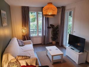 een woonkamer met een bank en een flatscreen-tv bij Charme de Provence - Piscine & Climatisation in Gréoux-les-Bains