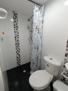 a bathroom with a white toilet and a shower at Casa La Fe in Cartagena de Indias