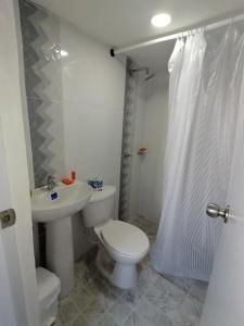 y baño con aseo, lavabo y ducha. en Casa La Fe, en Cartagena de Indias