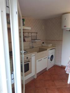 een keuken met een wastafel en een wasmachine bij Rescio's Rooms in Cavallino di Lecce