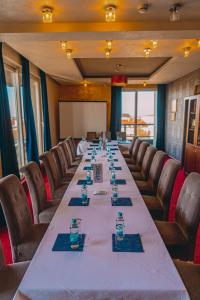 a long table in a room with chairs and glasses at Drina Hotel in Bijeljina