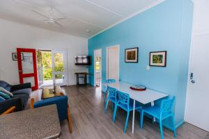 a living room with blue walls and a table and chairs at Kooyong Apartment 8 in Arcadia