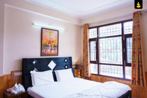 1 dormitorio con 1 cama y 2 ventanas grandes en LivingStone Cool Cottage Chail, en Chail