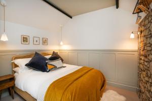 sypialnia z łóżkiem z żółtymi i czarnymi poduszkami w obiekcie The Queens Chew Magna w Bristolu