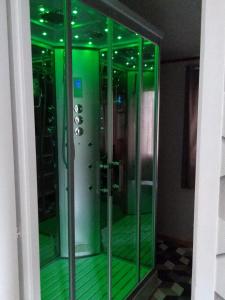 a glass elevator with green lights in a room at Chambre-Mobi-Loft , Baie-De-Somme in Arrest +14 photos