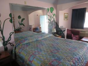 1 dormitorio con cama y espejo grande en Travelers Inn and Suites Liberty en Liberty