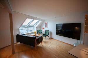 ein Wohnzimmer mit einem Sofa und einem großen TV in der Unterkunft Harbour View / Marina / City Centre in Tórshavn
