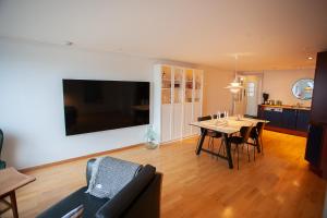 ein Wohnzimmer mit einem Tisch und einem TV an der Wand in der Unterkunft Harbour View / Marina / City Centre in Tórshavn