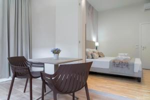 Zimmer mit einem Tisch, Stühlen und einem Bett in der Unterkunft Hotel Cosmos in Florenz