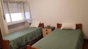 Duas camas num quarto com uma janela em Dunas House em Giz