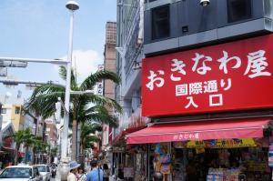 a red sign with chinese writing on a city street at Hotel Abest Naha Kokusai Street in Naha