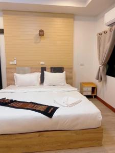 1 dormitorio con 1 cama blanca grande con almohadas blancas en The moon camp khanom, en Ban Plau