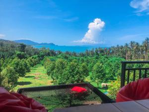 a bird cage with a red umbrella on a hill at The moon camp khanom in Ban Plau