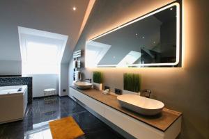 a bathroom with two sinks and a large mirror at Hotel Vienna beim Prater in Vienna