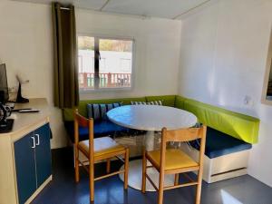 a small kitchen with a table and chairs in a room at Mobil Home - 4 personnes in Saint-Martin-Plage