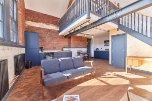 a living room with a couch and a staircase at No 7 at Simpson Street Apartments Sunderland in Sunderland