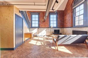 Una habitación abierta con una pared de ladrillos y una puerta. en No 7 at Simpson Street Apartments Sunderland, en Sunderland