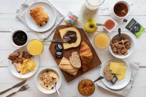 una mesa cubierta con platos de comida y bebida para el desayuno en B&B HOTEL Belfort Bessoncourt, en Belfort