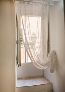 a window with a curtain in a room at Maison Tartarughe in Rome