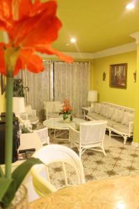 a living room with white furniture and a flower at Hotel Galleria in Davao City