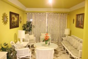 a living room with white chairs and a table and a table and chairsktop at Hotel Galleria in Davao City