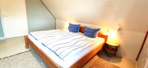 ein kleines Bett mit zwei blauen Kissen in einem Zimmer in der Unterkunft Gästehaus Zur alten Post Wohnung Ost in Dornum