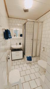 a white bathroom with a shower and a toilet at Gaestehaus-Zur-alten-Post-Wohnung-Ost in Dornum