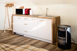 a kitchen counter with a sink and a trash can at Glamping Bahenec in Bahenec