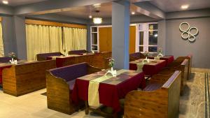 a restaurant with wooden tables and chairs with red table cloth at Hotel Snow View on Cloud Nine in Pelling