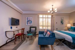 een slaapkamer met een bed en een tafel en stoelen bij Fair Acres Boutique Hotel Karen in Nairobi