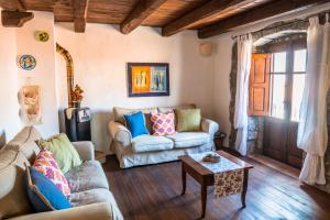 a living room with two couches and a table at Su Cucumiao - Tipica casa con terraza panoramica in Santu Lussurgiu