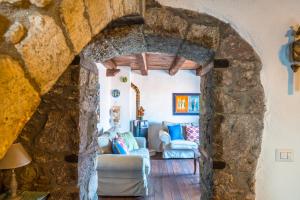 a living room with a stone wall at Su Cucumiao - Tipica casa con terraza panoramica in Santu Lussurgiu