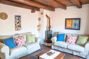 a living room with two couches and a wood stove at Su Cucumiao - Tipica casa con terraza panoramica in Santu Lussurgiu