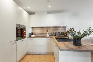 a kitchen with white cabinets and a wooden counter top at Host & Stay - Farrier William in Margate
