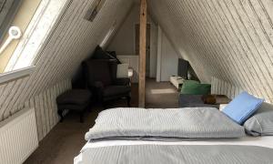 Habitación en el ático con cama y silla en Villa Brockenhexe, en Braunlage