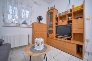 een woonkamer met een tv en een houten entertainmentcentrum bij M Entire floor in a spacious house with pool in Podstrana