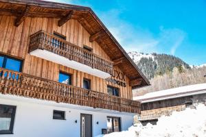 un edificio con balcón en la nieve en LUXX Lodges - Holzgau - Lechtal - Arlberg, en Holzgau