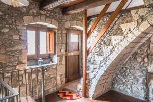 a stone staircase in a house with a stone wall at Su Cucumiao - Tipica casa con terraza panoramica in Santu Lussurgiu