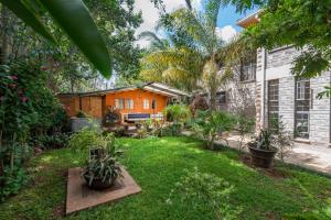 een tuin met een huis op de achtergrond bij Fair Acres Boutique Hotel Karen in Nairobi