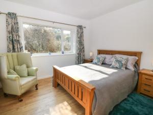 - une chambre avec un lit, une chaise et une fenêtre dans l'établissement The Headland, à Amlwch