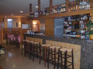 a bar with bar stools in a restaurant at Amolls Restaurant i Habitacions in Olot